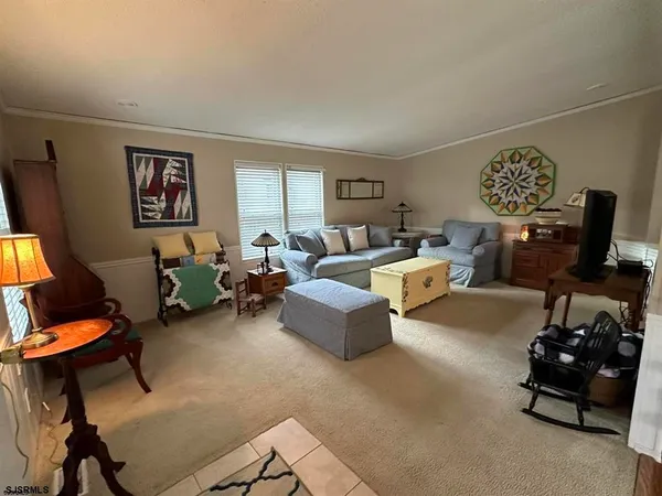 a view of a dining room and livingroom with furniture wooden floor a chandelier