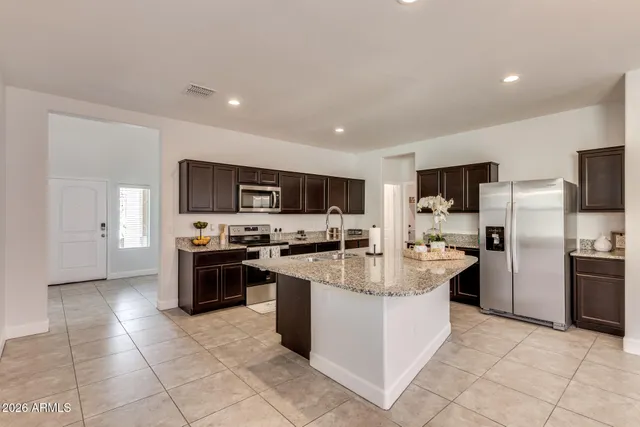 a large kitchen with stainless steel appliances granite countertop a large counter top and a stove top oven