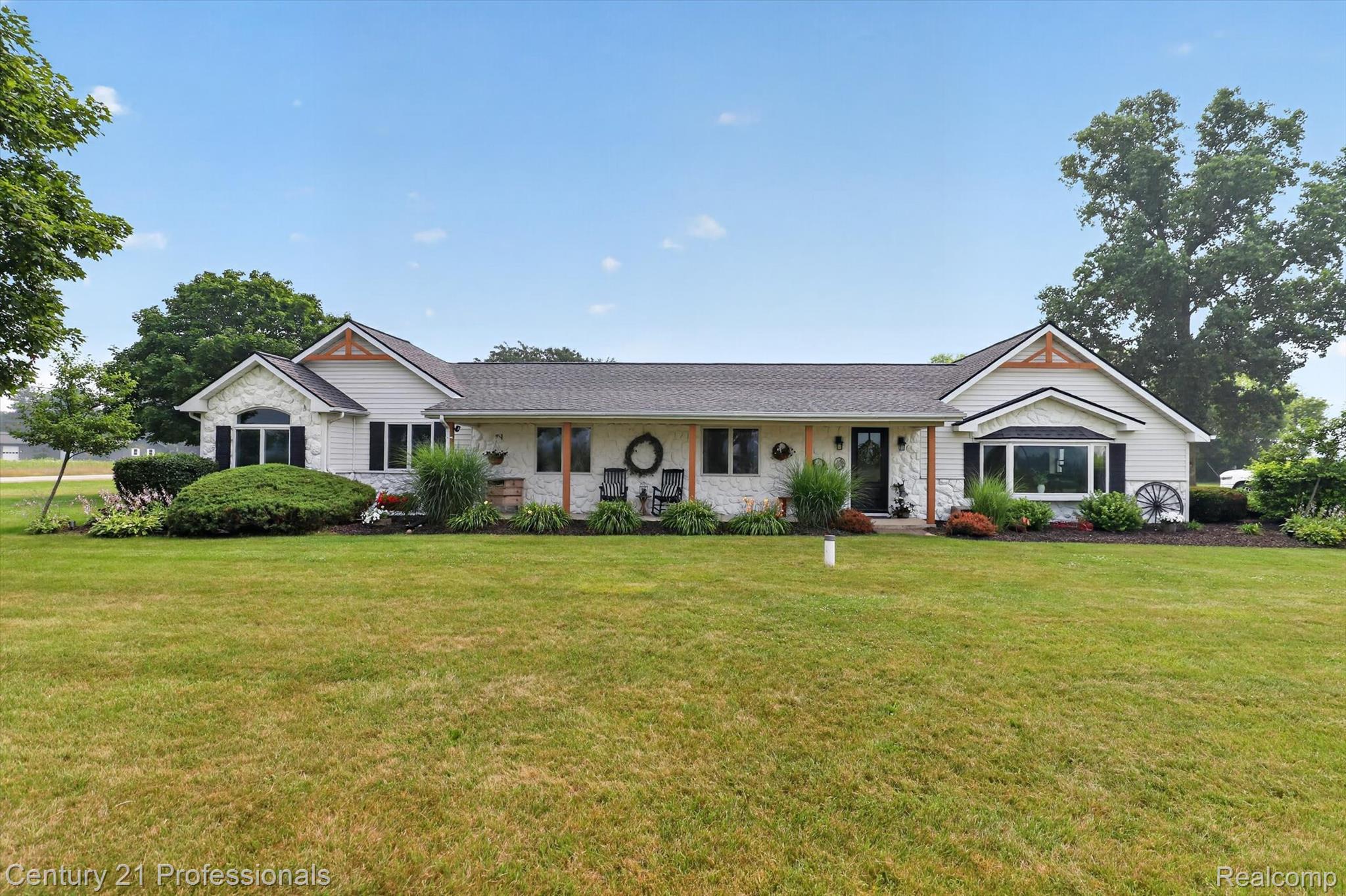 13525 Dennison Road Milan, MI 48160 - Photo 1 of 69 White siding residence with stone veneer accents, an expansive front lawn, dark shingle roofing, and covered front porch