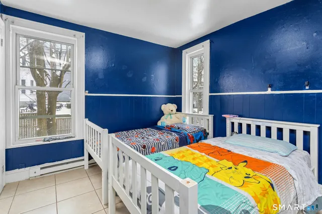 a bed sitting in a bedroom next to a window