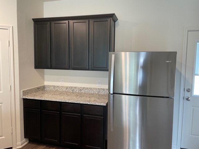 18741 Speculator Lane Elgin, TX 78621 - Photo 10 of 28 a kitchen with a refrigerator and cabinets