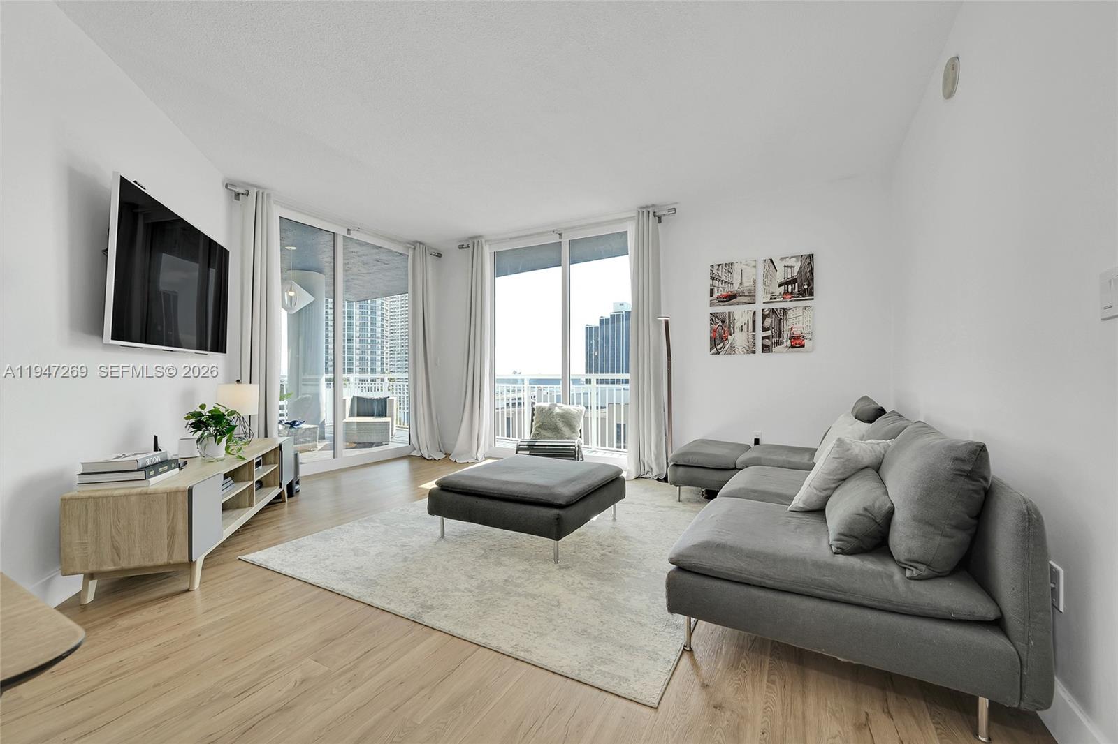 275 Northeast 18th Street, Unit 1207 Miami, FL 33132 - Photo 11 of 31 a living room with furniture window and a flat screen tv