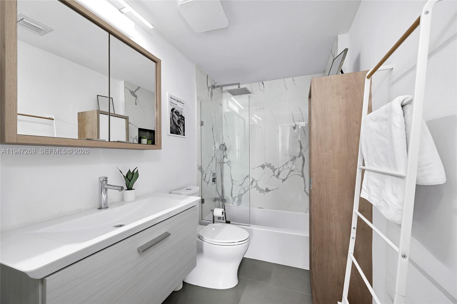 275 Northeast 18th Street, Unit 1207 Miami, FL 33132 - Photo 18 of 31 a bathroom with a granite countertop sink toilet a shower and a mirror