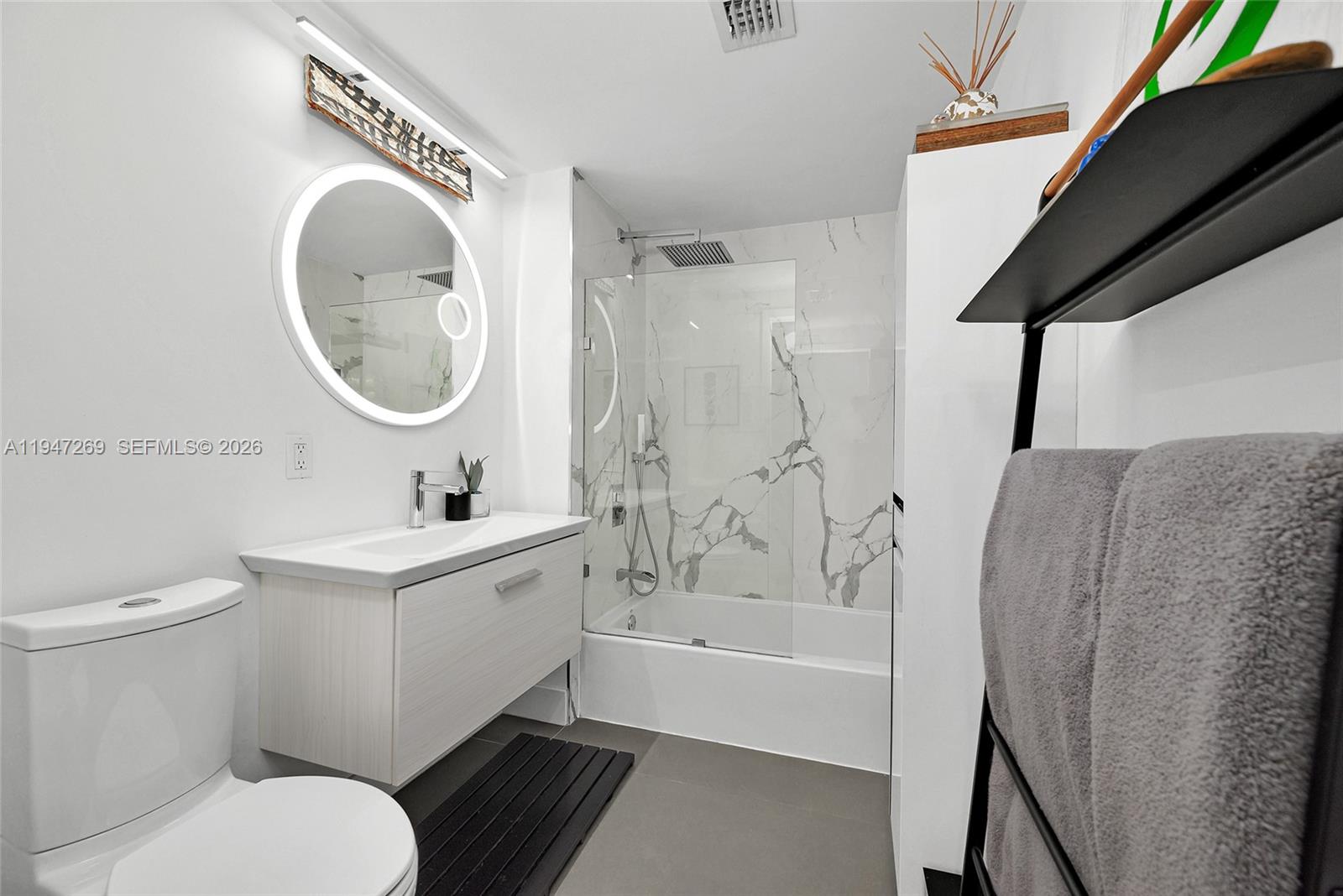 275 Northeast 18th Street, Unit 1207 Miami, FL 33132 - Photo 21 of 31 a bathroom with a sink a toilet and a mirror