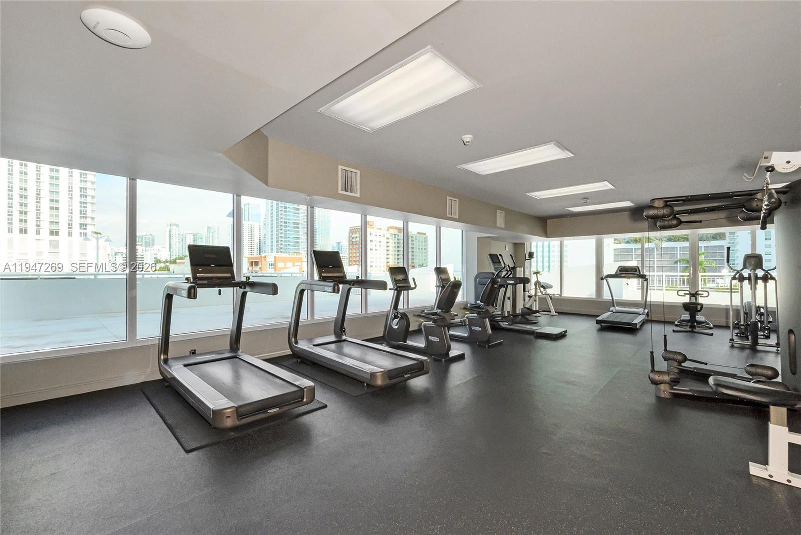 275 Northeast 18th Street, Unit 1207 Miami, FL 33132 - Photo 28 of 31 a living room with gym equipment and large windows