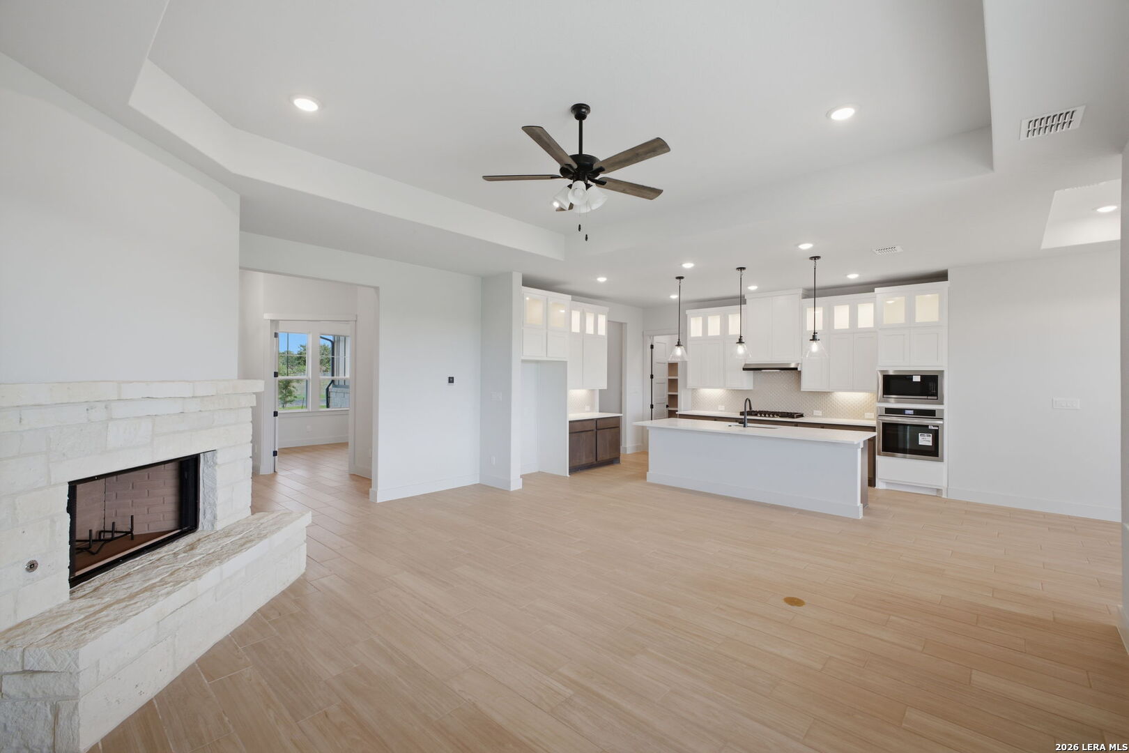 171 Pradera Ridge Drive Floresville, TX 78114 - Photo 8 of 18 a large white kitchen with kitchen island a sink stainless steel appliances and cabinets