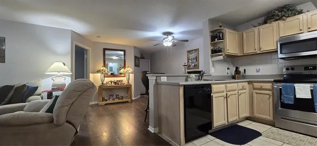 a living room with furniture a chandelier and kitchen view