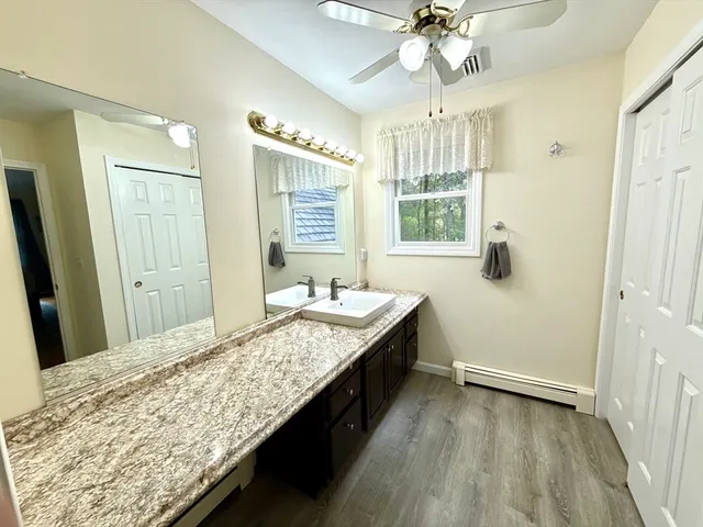 a bathroom with a granite countertop sink a large mirror and a shower