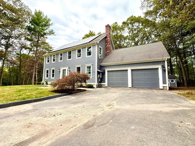 a view of a house with a yard and large tree