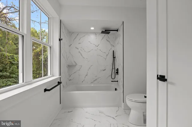 a bathroom with a bathtub shower and toilet
