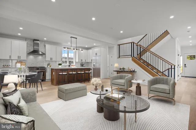 a living room with furniture and a dining table with kitchen view