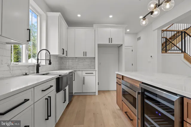 a kitchen with stainless steel appliances sink a stove and cabinets