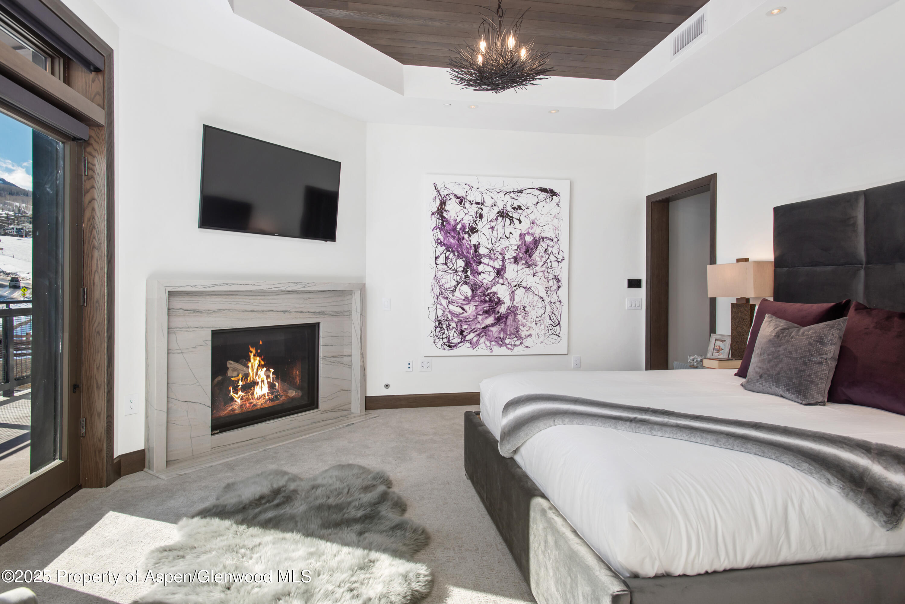 65 Wood Road, Unit 517 Snowmass Village, CO 81615 - Photo 11 of 28 a spacious bedroom with a bed and a fireplace