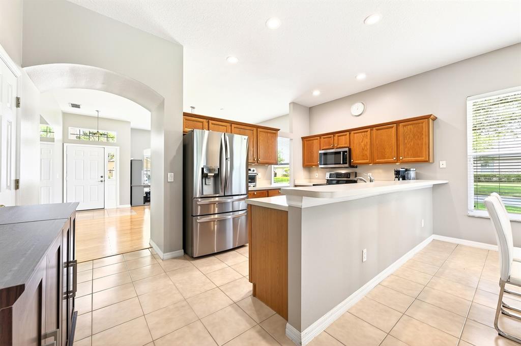 990 Ridgemount Place Lake Mary, FL 32746 - Photo 12 of 46 a kitchen with stainless steel appliances a refrigerator sink and cabinets