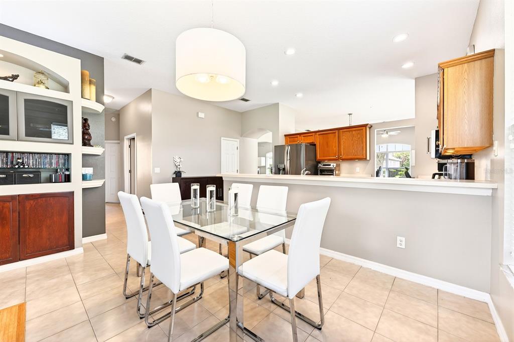 990 Ridgemount Place Lake Mary, FL 32746 - Photo 14 of 46 a kitchen with stainless steel appliances kitchen island granite countertop a dining table chairs and a refrigerator