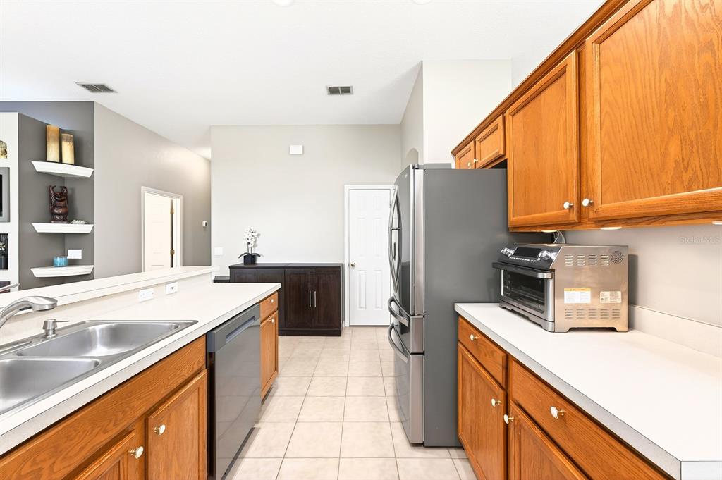 990 Ridgemount Place Lake Mary, FL 32746 - Photo 9 of 46 a kitchen with a sink a counter top space stainless steel appliances cabinets and a counter top space