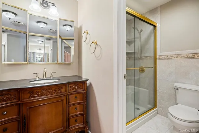 a bathroom with a granite countertop sink a toilet and a mirror