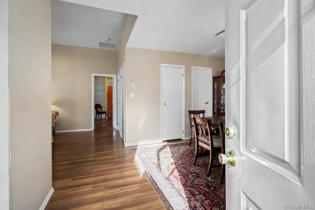 a view of a hallway with wooden floor and furniture