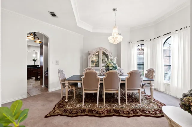 a dining room with furniture a chandelier and wooden floor