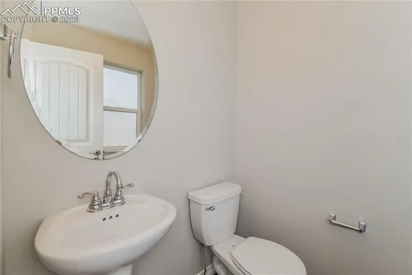 a bathroom with a toilet a sink and mirror