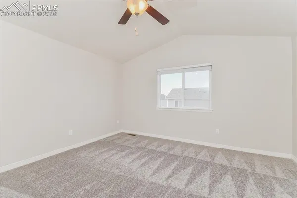 an empty room with a window and ceiling fan