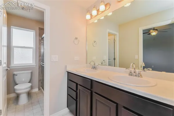 a spacious bathroom with a granite countertop sink a toilet and a mirror