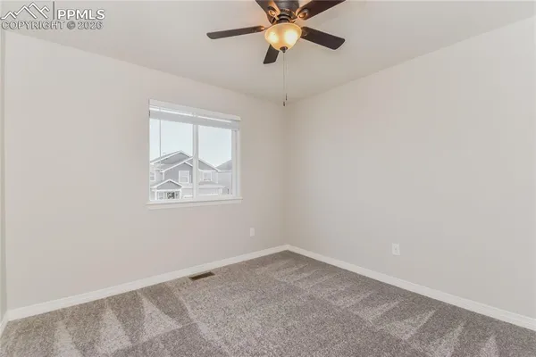 an empty room with a window and a fan