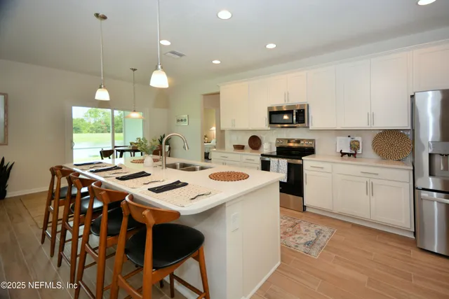 a kitchen with a sink a stove a refrigerator and cabinets