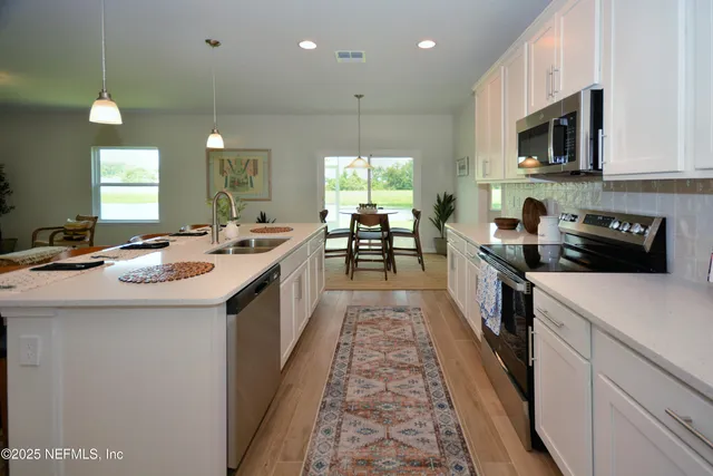a kitchen with counter top space a sink and appliances