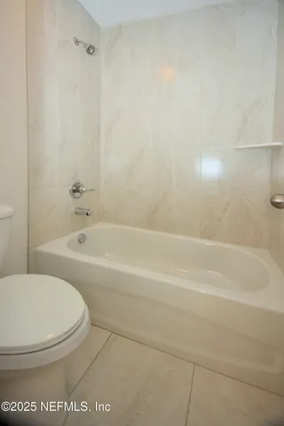 a white toilet sitting next to a bath tub