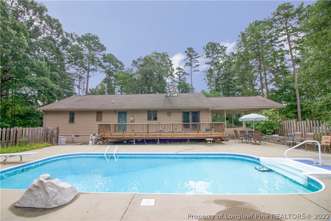 144 Manor Road Carthage, NC 28327 - Photo 20 of 47 a backyard of a house with table and chairs under an umbrella