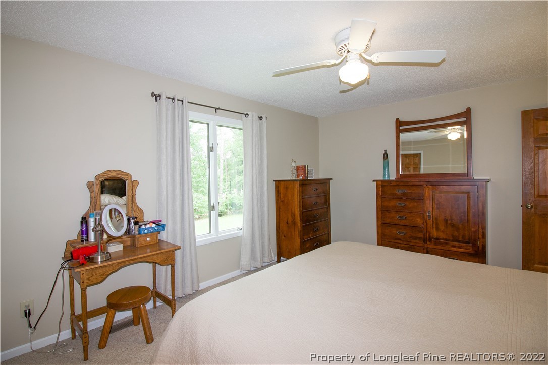 144 Manor Road Carthage, NC 28327 - Photo 27 of 47 a bedroom with a bed and a chandelier