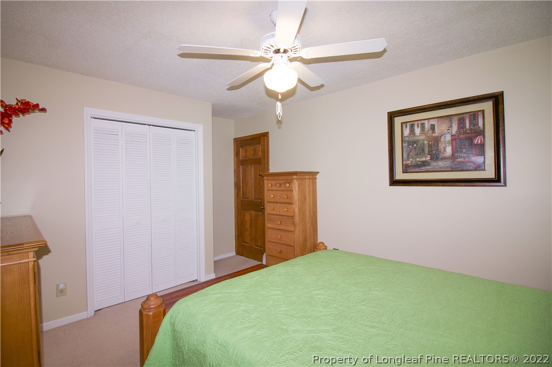 144 Manor Road Carthage, NC 28327 - Photo 30 of 47 a bedroom with a bed and a chandelier