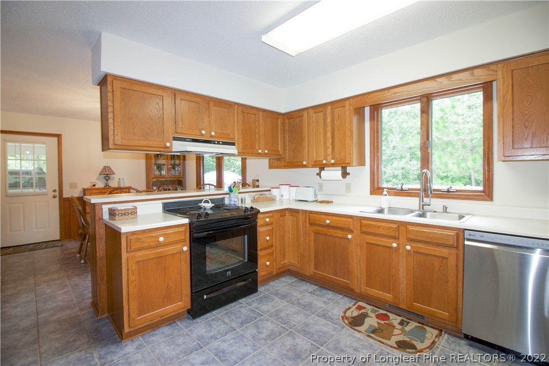144 Manor Road Carthage, NC 28327 - Photo 41 of 47 a kitchen with stainless steel appliances granite countertop a stove a sink and a microwave