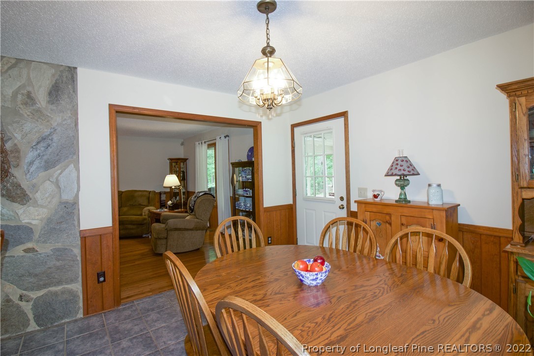 144 Manor Road Carthage, NC 28327 - Photo 44 of 47 a view of a dining room with furniture a chandelier and wooden floor