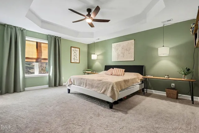 a spacious bedroom with a large bed and a chandelier