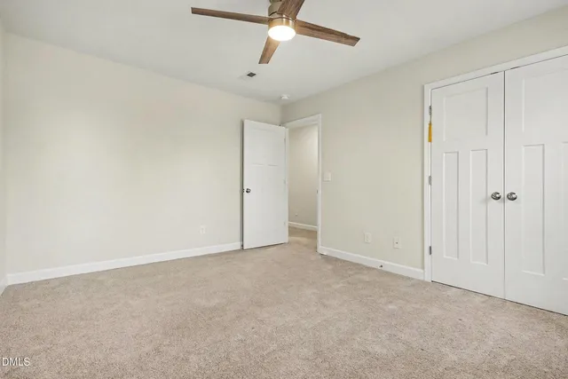 an empty room with a ceiling fan and a window