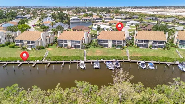 an aerial view of residential houses with outdoor space and lake view