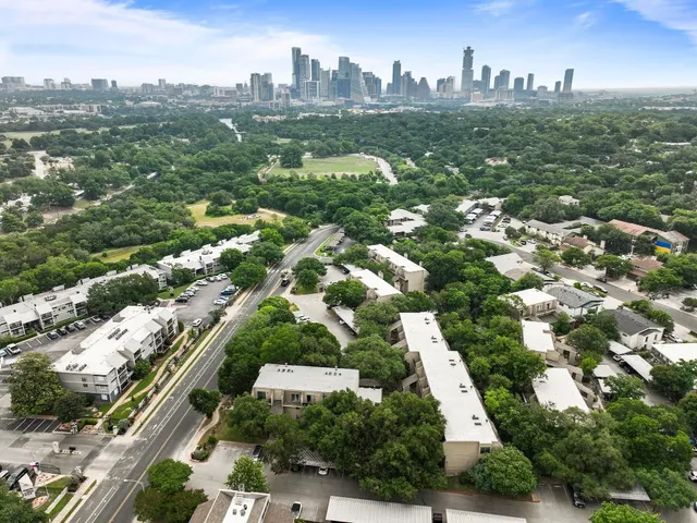 a front view of a house with garden and trees