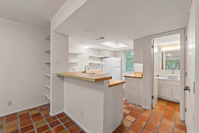 a kitchen with granite countertop a sink and a refrigerator