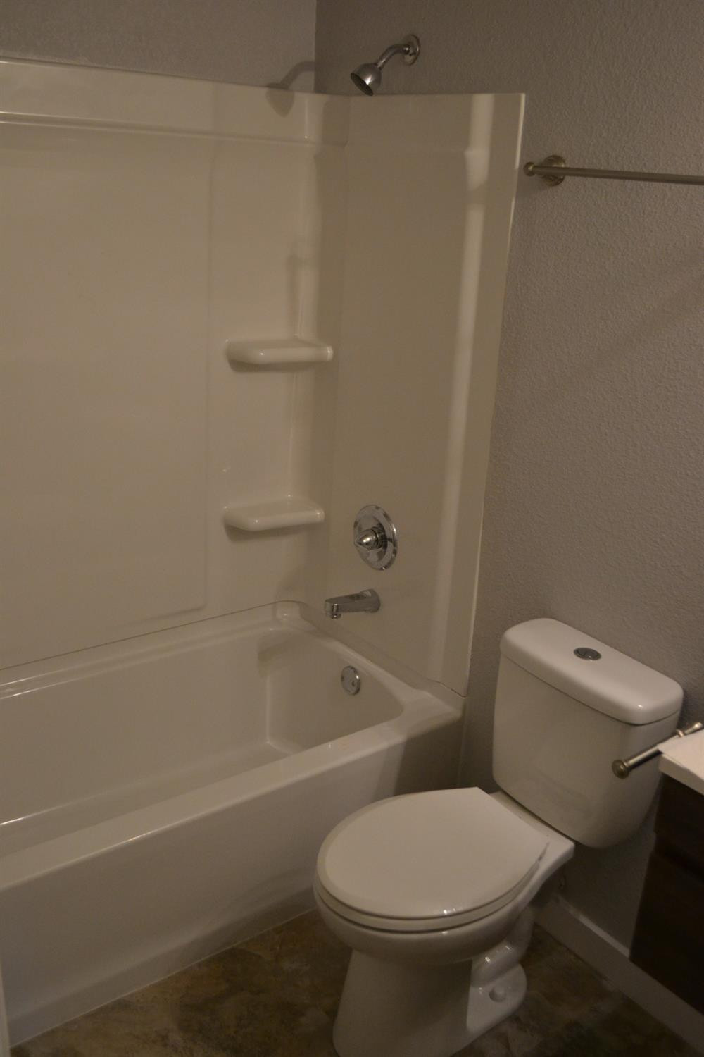 1812 14th Street, Unit 5 Lubbock, TX 79401 - Photo 10 of 10 a white toilet and tub sitting next to a bathroom sink