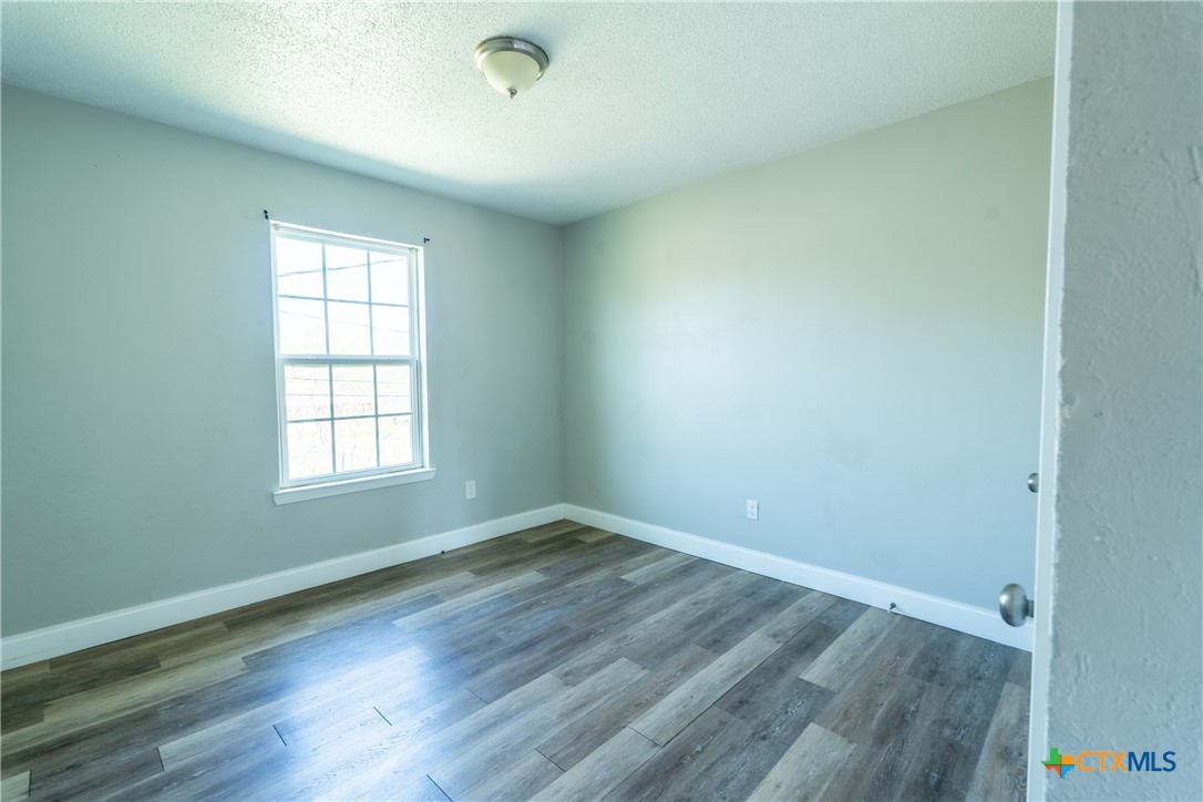 512 Sunset Lane, Unit AD Copperas Cove, TX 76522 - Photo 11 of 23 an empty room with wooden floor and windows