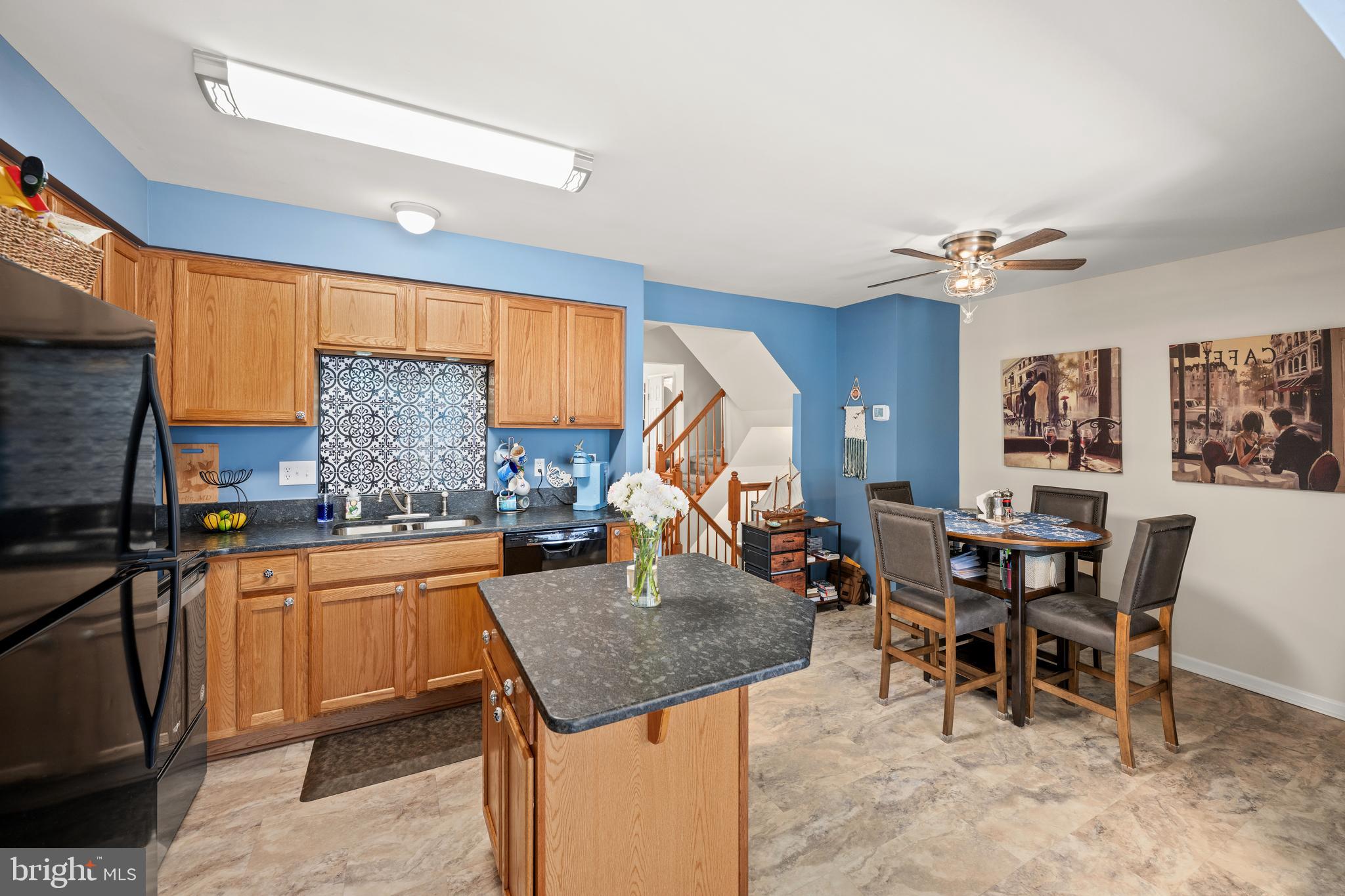 27548 Mayfield Road, Unit 42 Millsboro, DE 19966 - Photo 12 of 46 a kitchen with a table chairs and a refrigerator