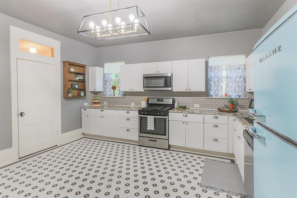 453 East Marshall Street Van Alstyne, TX 75495 - Photo 15 of 30 a kitchen with a stove a sink and a microwave