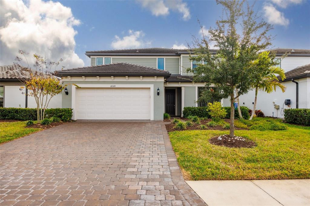 a front view of a house with a yard garage and outdoor seating