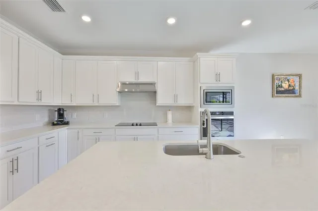 a kitchen with stainless steel appliances granite countertop a sink and cabinets