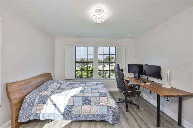 a bedroom with a bed and wooden floor