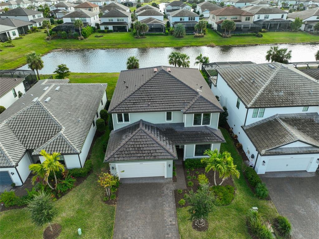16320 Hidden Oak Loop Bradenton, FL 34211 - Photo 3 of 56 an aerial view of a house with a garden and lake view