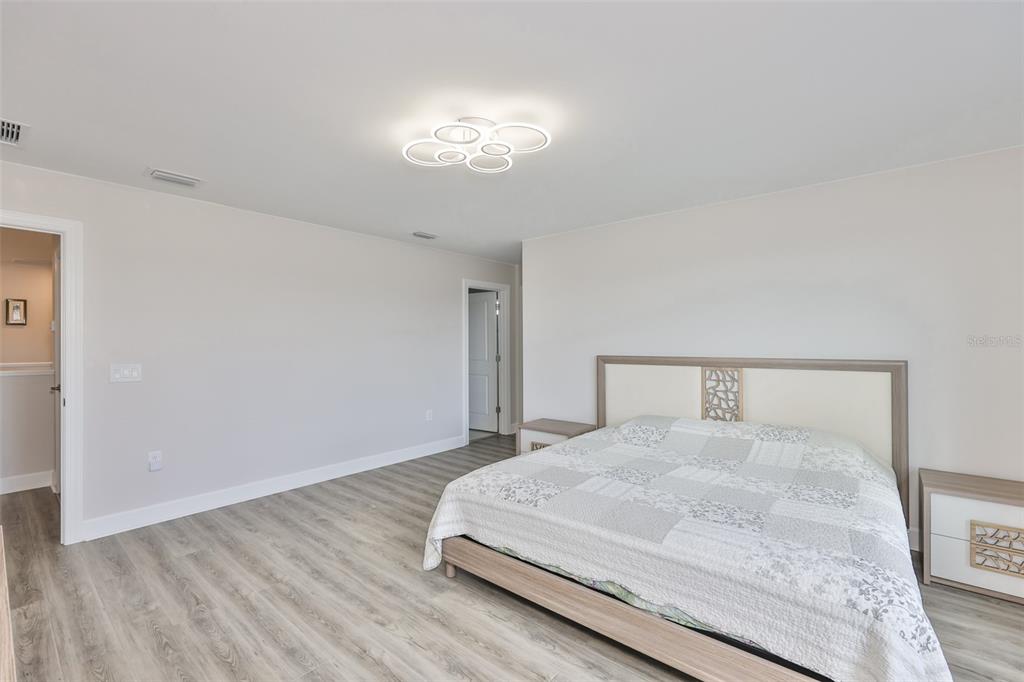 16320 Hidden Oak Loop Bradenton, FL 34211 - Photo 40 of 56 a bedroom with a bed and a chandelier