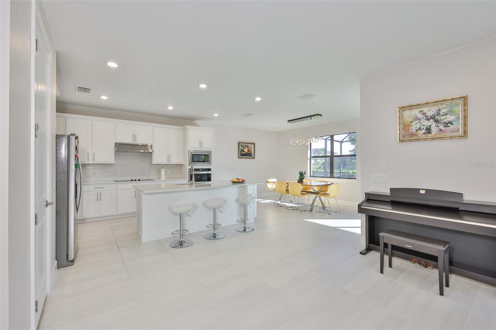 16320 Hidden Oak Loop Bradenton, FL 34211 - Photo 9 of 56 a living room with white couches and furniture with kitchen view